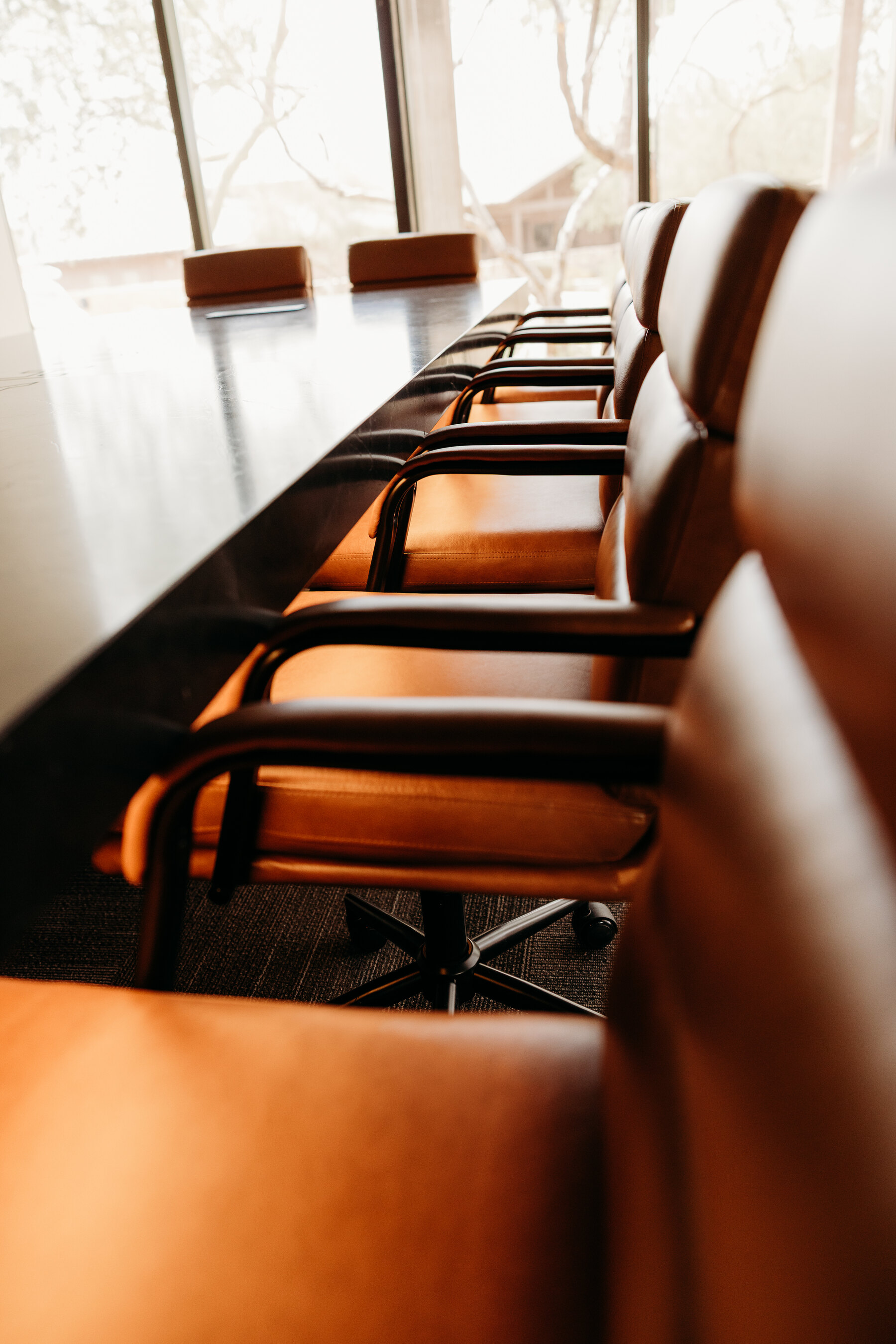 LED lighting under the stone top of a custom conference table glowing across executive leather seating