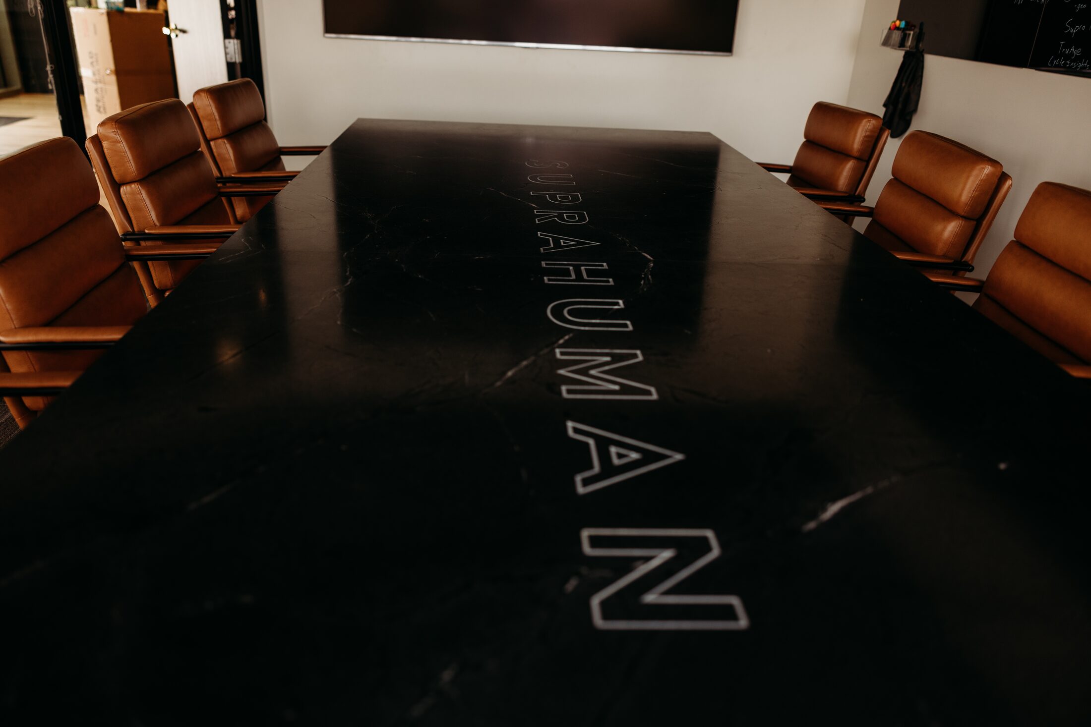 Company logo engraved and inlaid into the black marble top of a custom boardroom table in Arizona